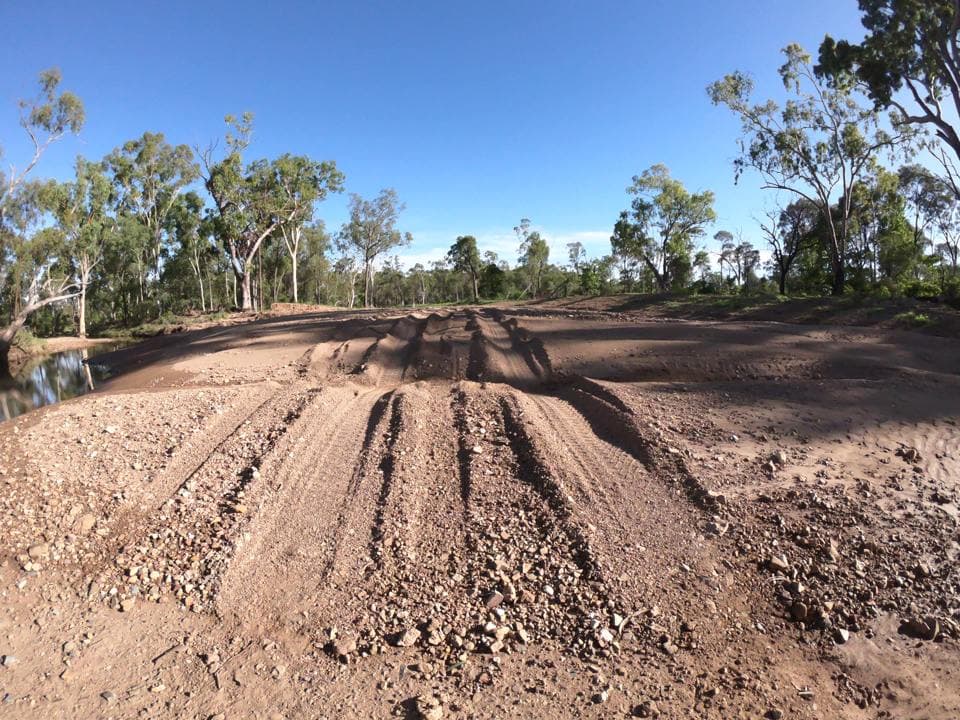 Flood damage on an unsealed road: rutted gravel and wheel tracks
