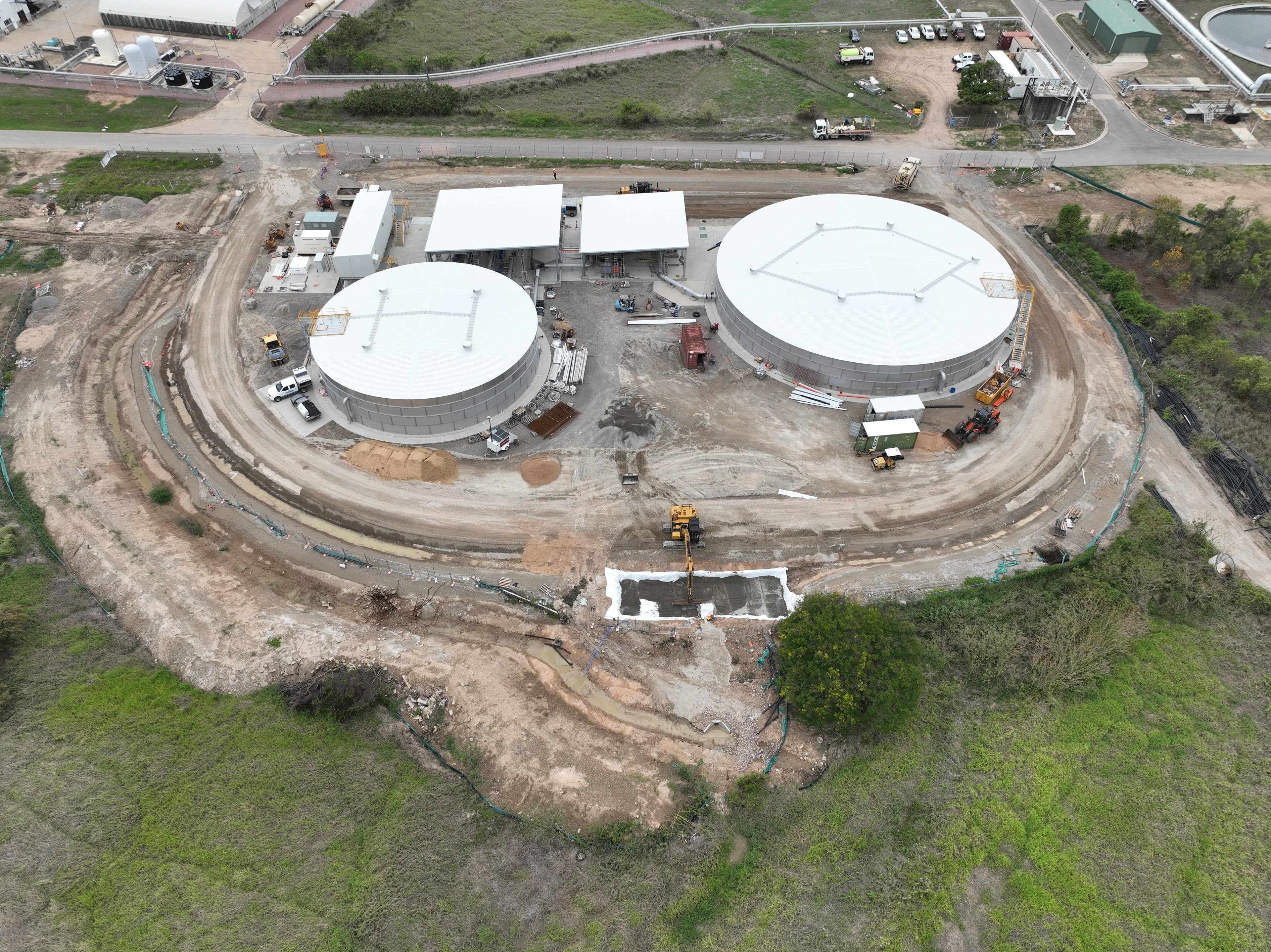 Aerial view of the recycled water treatment facility under construction, with two large circular tanks